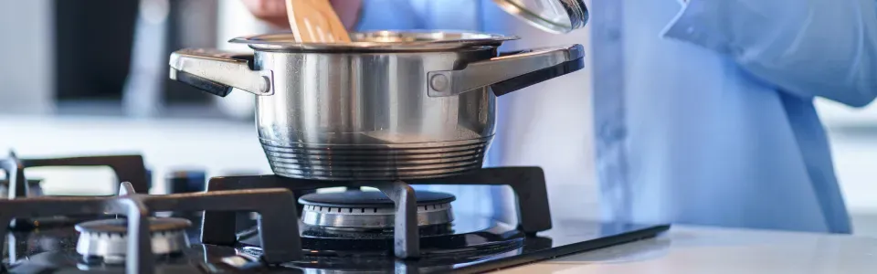 photo of someone cooking using a gas range